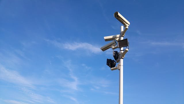 Surveillance Cameras on a pole. Blue Sky on background.