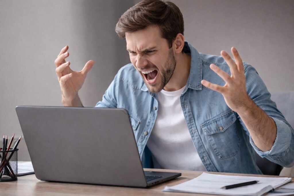 Frustrated man reacting to an artificial intelligence error while looking at a laptop